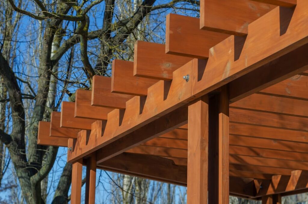 Drewniana konstrukcja zbudowana z deseczek do altan wśród drzew.